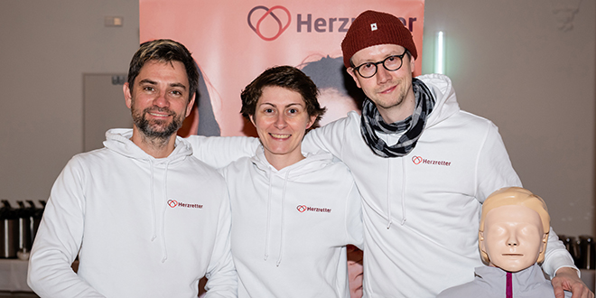 Herzretter Leipzig als Gruppe mit Puppe vor einem Banner der Herzretter